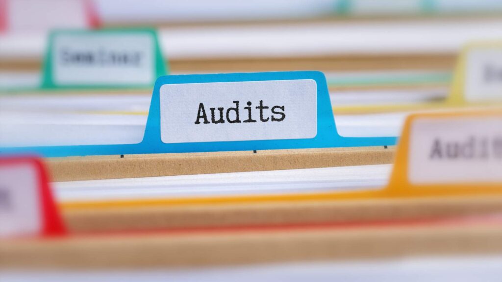 File folders labeled “Audits,” representing customs audit preparation and compliance documentation.