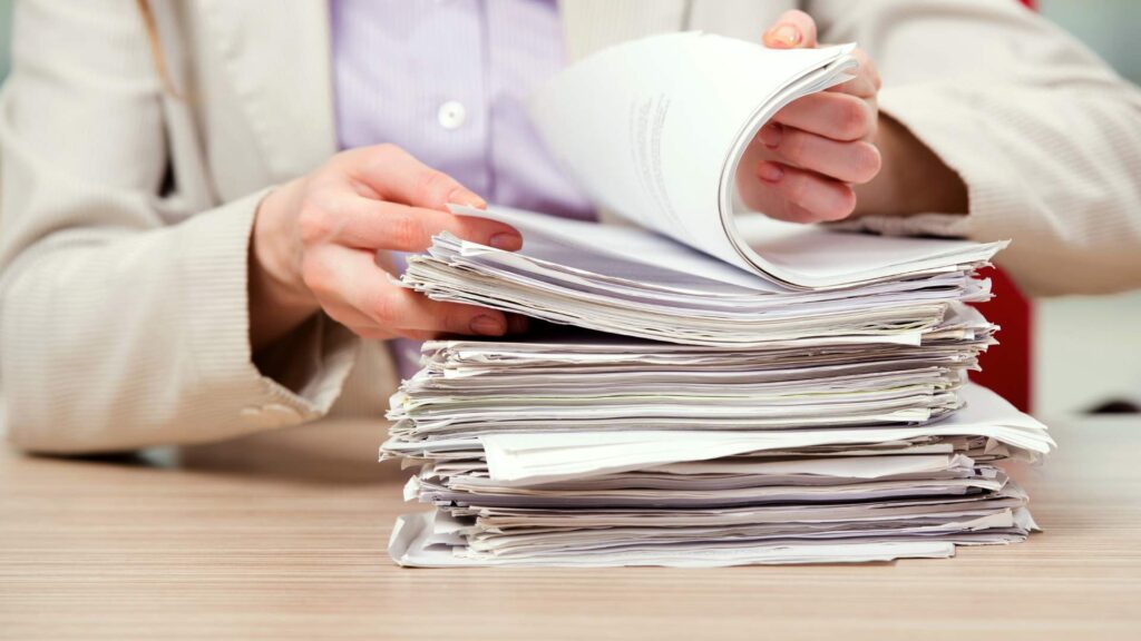 Person reviewing a stack of import paperwork related to US customs entry types and CBP documentation