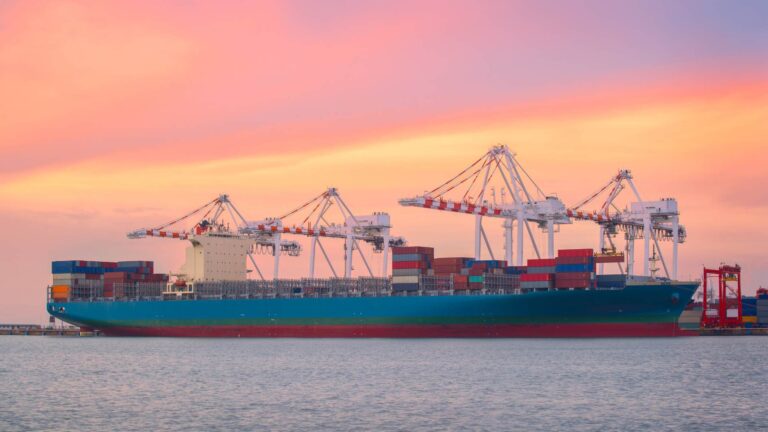 Container ship at port with cranes loading cargo containers, representing global trade and import export logistics