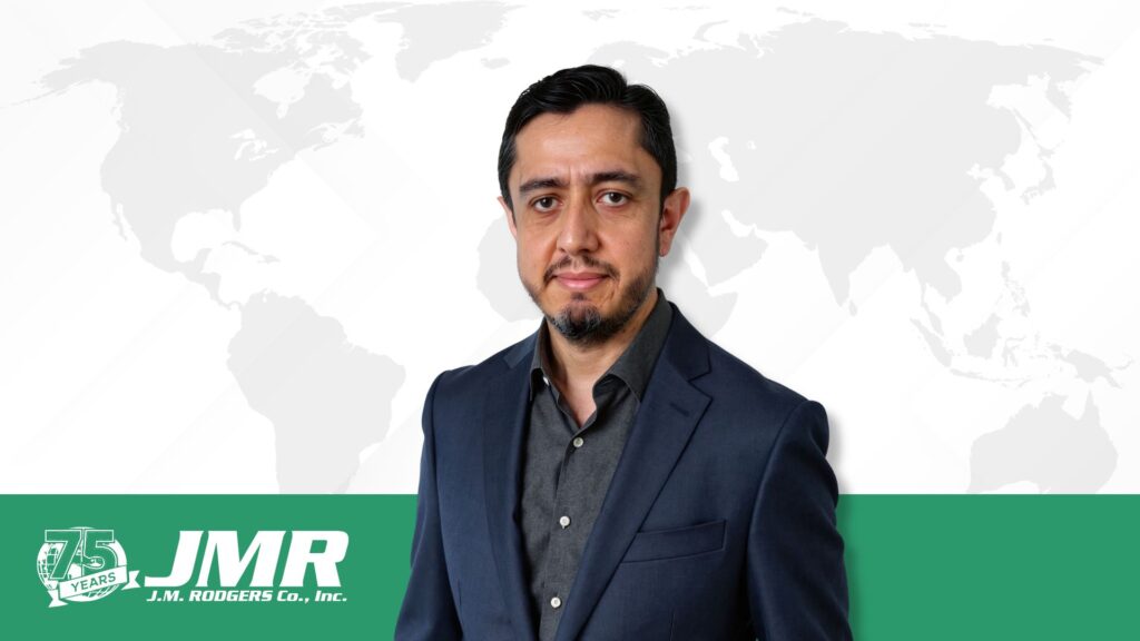 A headshot of the President of J.M. Rodgers, Diego Vargas, in front of a global trade map.