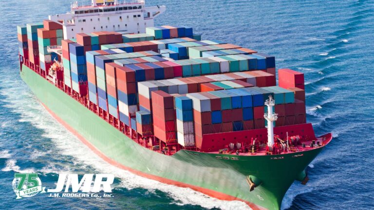 Freight ship on the ocean with a JMR 75th Anniversary logo.