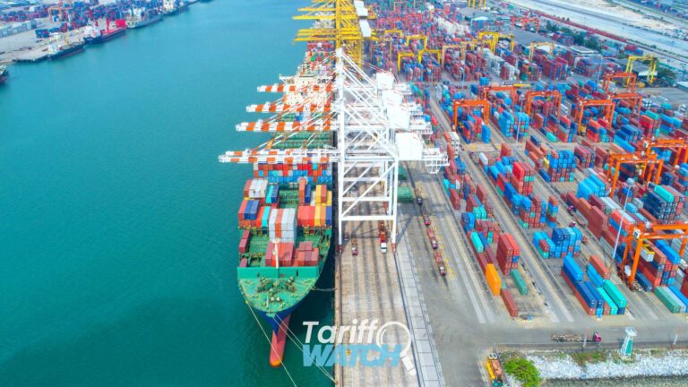 Container ship at a commercial cargo port representing Section 232 tariffs on polysilicon, Section 301 textile TRQ delays, Section 338 tariffs on Canada, customs compliance, and global trade developments featured in Tariff Watch.